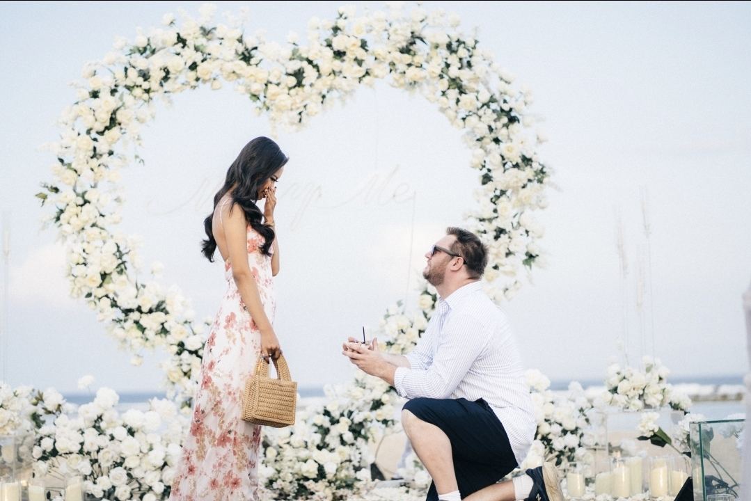 Boyd on one knee beneath the floral heart